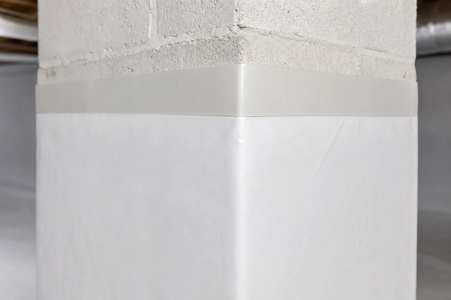 A concrete pier wrapped in liner and terminated with a taped band
